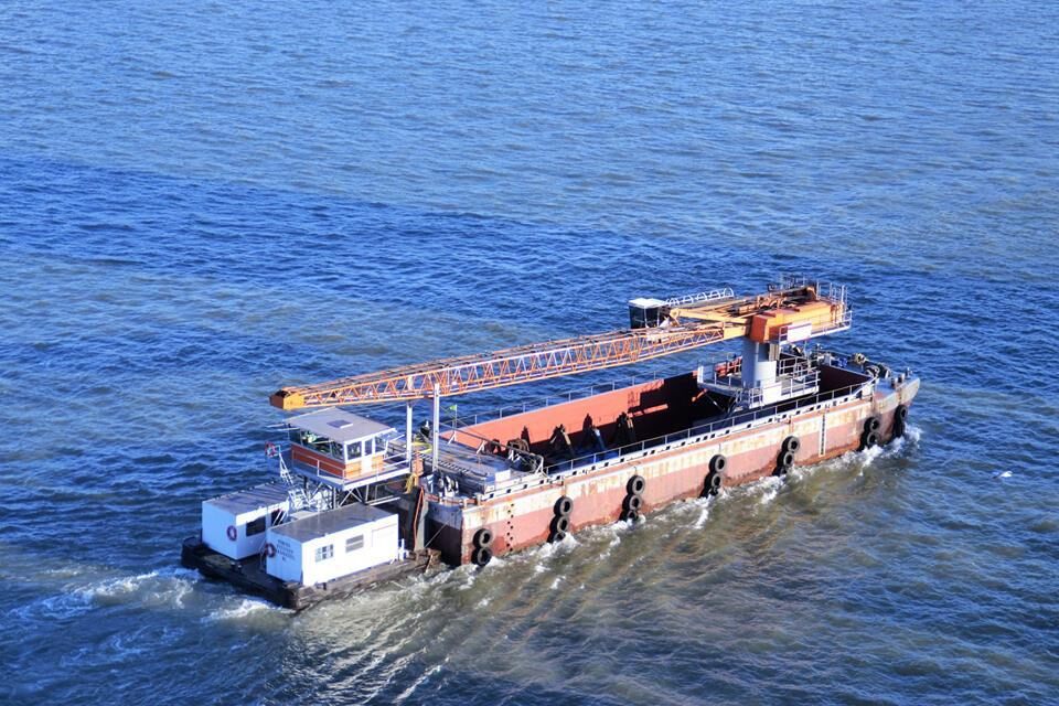 Schwimmkran auf einem Ponton, fahrend mit einem Schubboot auf dem Fluss